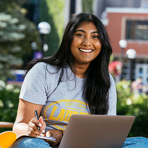 student studying at laptop outside