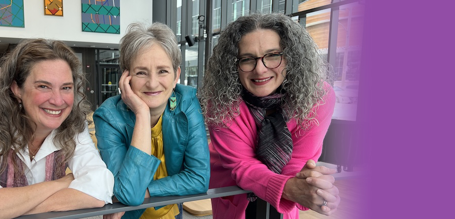 Three voice lab instructors leaning on a railing in the Savvas Chamberlain Music Building atrium