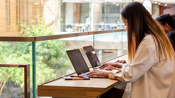 Student using computer on second floor of Lazaridis Hall.