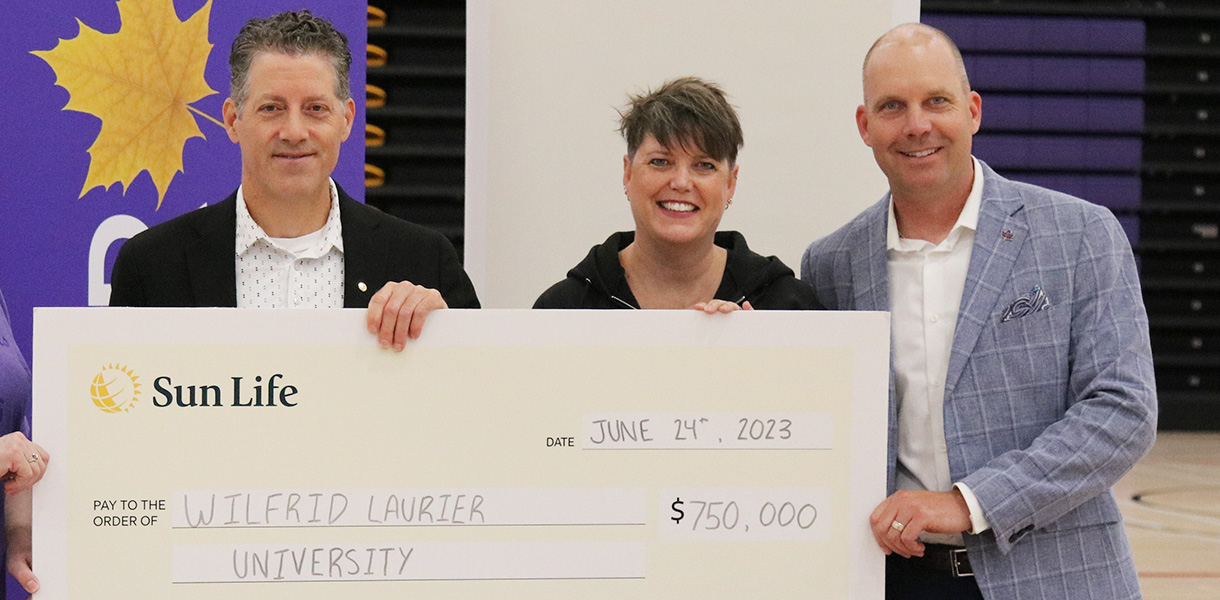 Representative from Sun Life presenting cheque to Laurier staff members