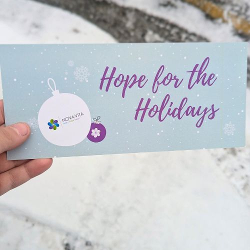 A hand holds an envolope.