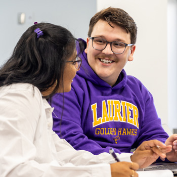 male student smiling and female student in science classroom