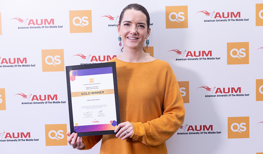 Charity Parr-Vasquez holding a plaque at the QS Awards